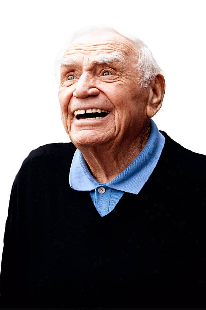 Smile 桌布 壁紙 — 一位白髮長者，在純白背景前，穿著黑色毛衣搭配藍色有領襯衫，開懷大笑。