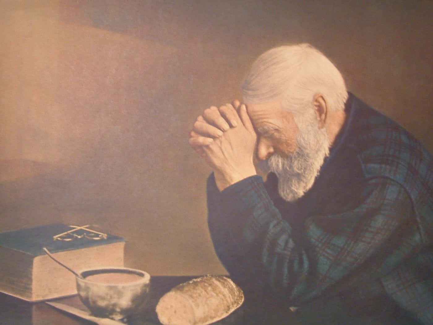 Praying 桌布 壁紙 — 一位白鬍子長者在溫暖昏暗的光線下，雙手合十在聖經碗和麵包旁邊祈禱。