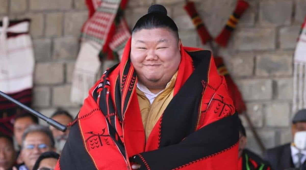 搞笑臉 桌布 壁紙 — 一位相撲選手身穿鮮豔的紅黑儀式長袍，在石牆背景下洋溢著喜悅。