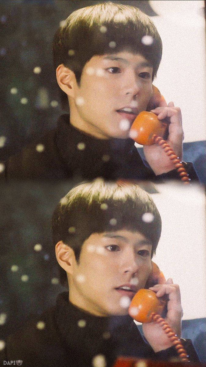 Reply 1988 桌布 壁紙 — 一位短棕髮的年輕男子將橙色轉盤電話貼在耳邊，身後窗外雪花飄落。