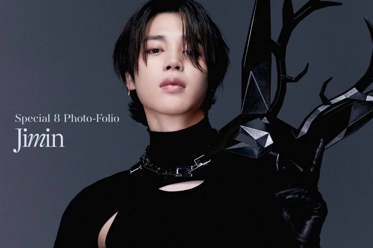 Bts Jimin 桌布 壁紙 — 一位短黑髮的人穿著黑色服裝，配戴幾何鹿角狀飾品，背景為柔和的灰色。