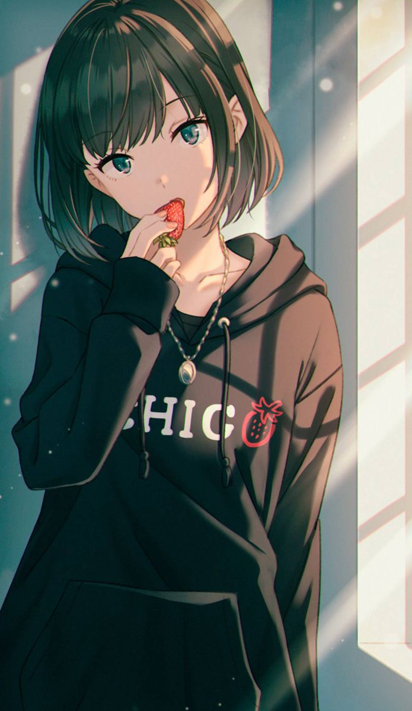 Cute Anime Girl 桌布 壁紙 — 一位短黑髮藍眼的年輕動漫女孩，站在陽光照射的窗邊，穿著黑色連帽衫，咬著草莓。