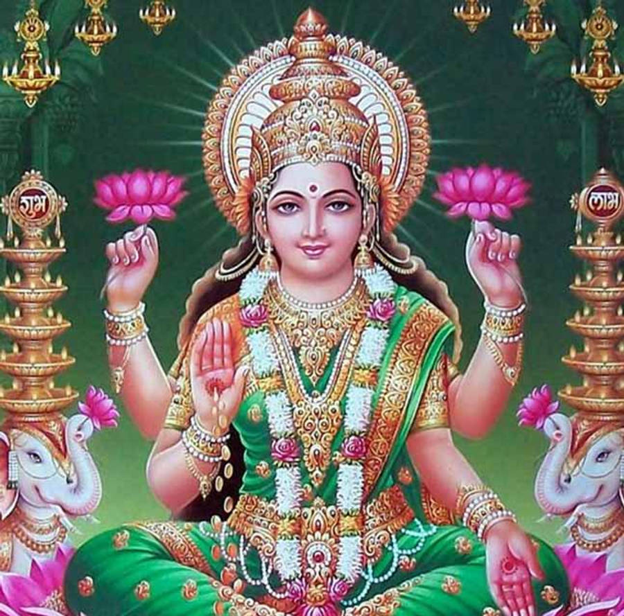 Lakshmi Devi 桌布 壁紙 — 一位神聖的女神身穿華麗的綠色和金色服飾，手持粉紅色蓮花，坐在大象兩側，背景是明亮的綠色。