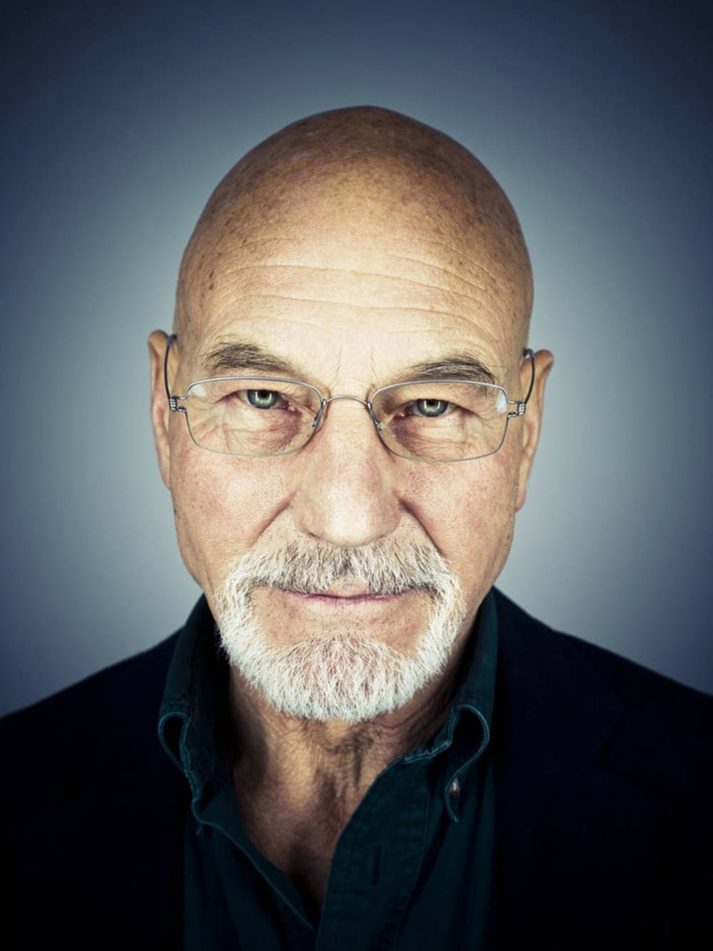 Celebrity 桌布 壁紙 — 一位禿頭、戴眼鏡、留白鬍子的年長男士的頭像特寫，背景為漸變藍色。