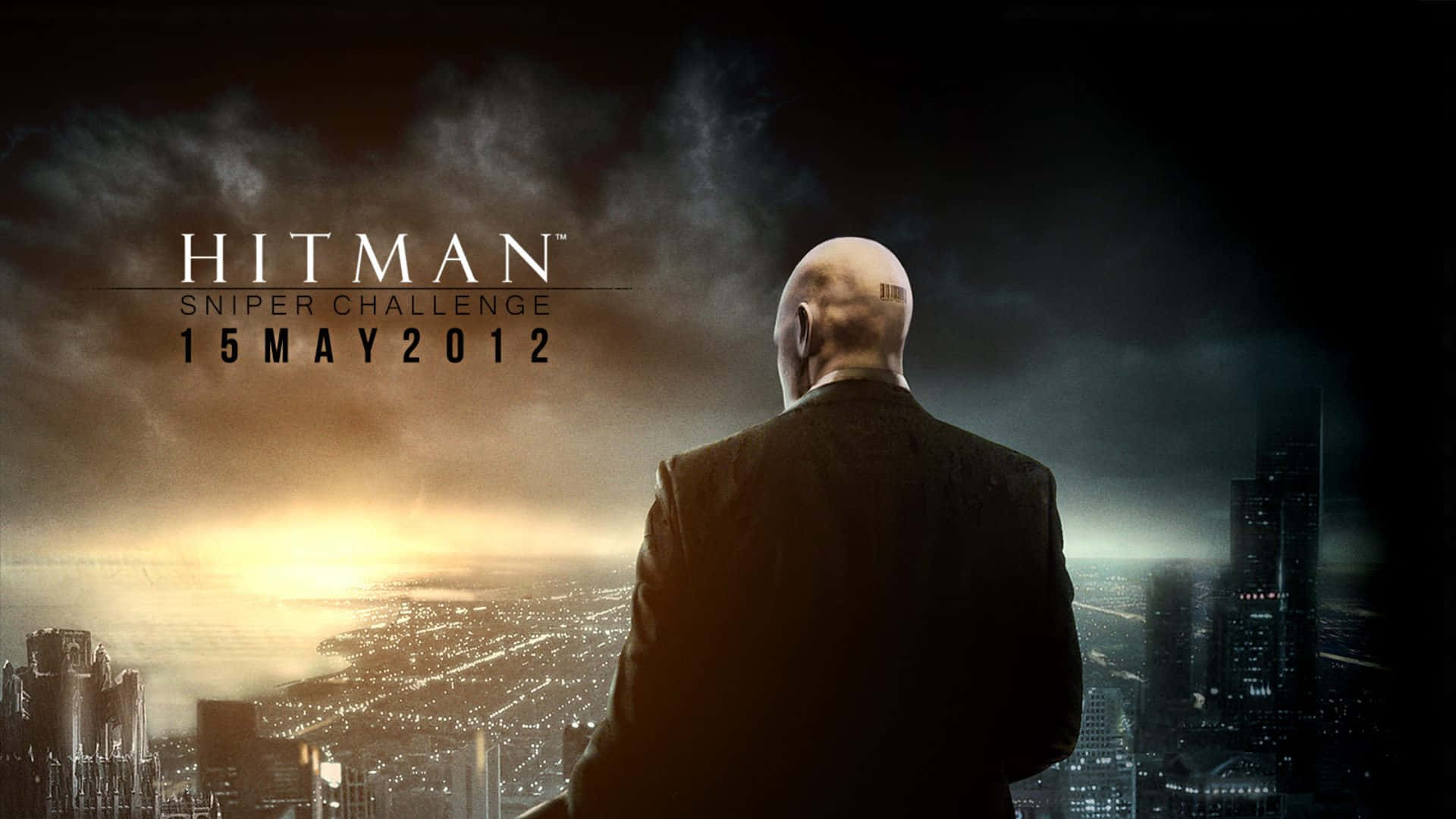 Hitman 2 桌布 壁紙 — 一位禿頭男子穿著西裝，俯瞰著黃昏時分廣闊的城市天際線，伴隨著戲劇性的雲彩和發光的天際線。