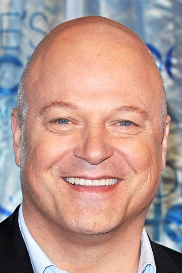 Smile 桌布 壁紙 — 一位禿頭藍眼男士穿著深色西裝和淺藍色襯衫，溫暖微笑的特寫肖像。