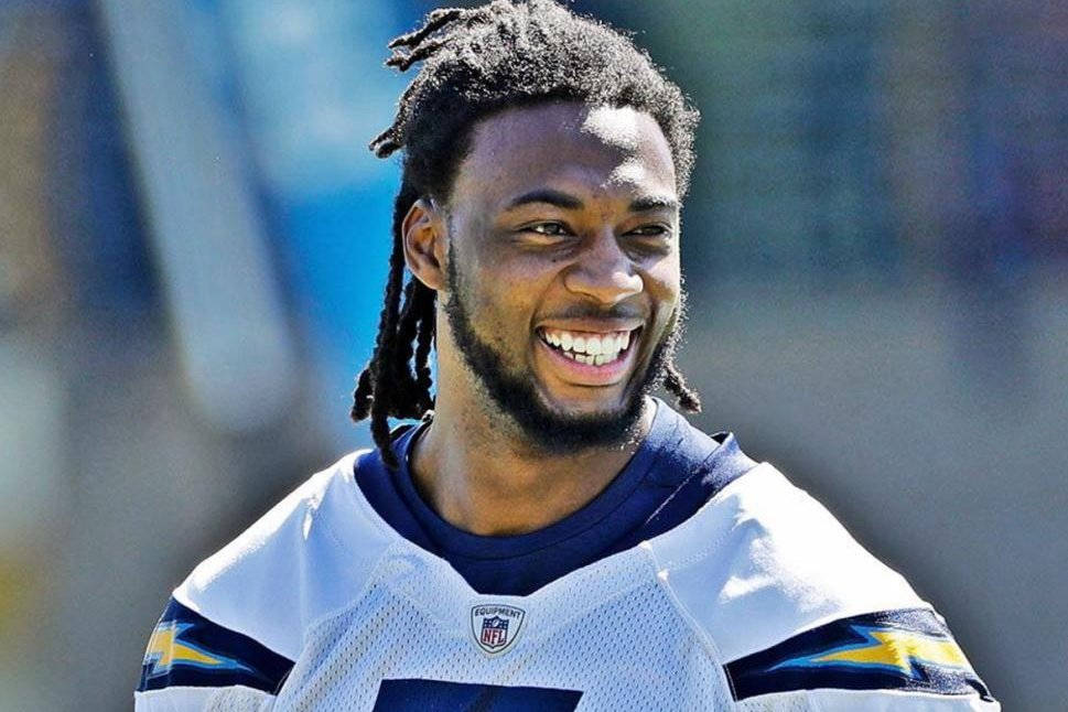 運動 桌布 壁紙 — 一位穿著 Chargers 球衣的足球運動員在明媚陽光下笑容滿面，洋溢著喜悅。