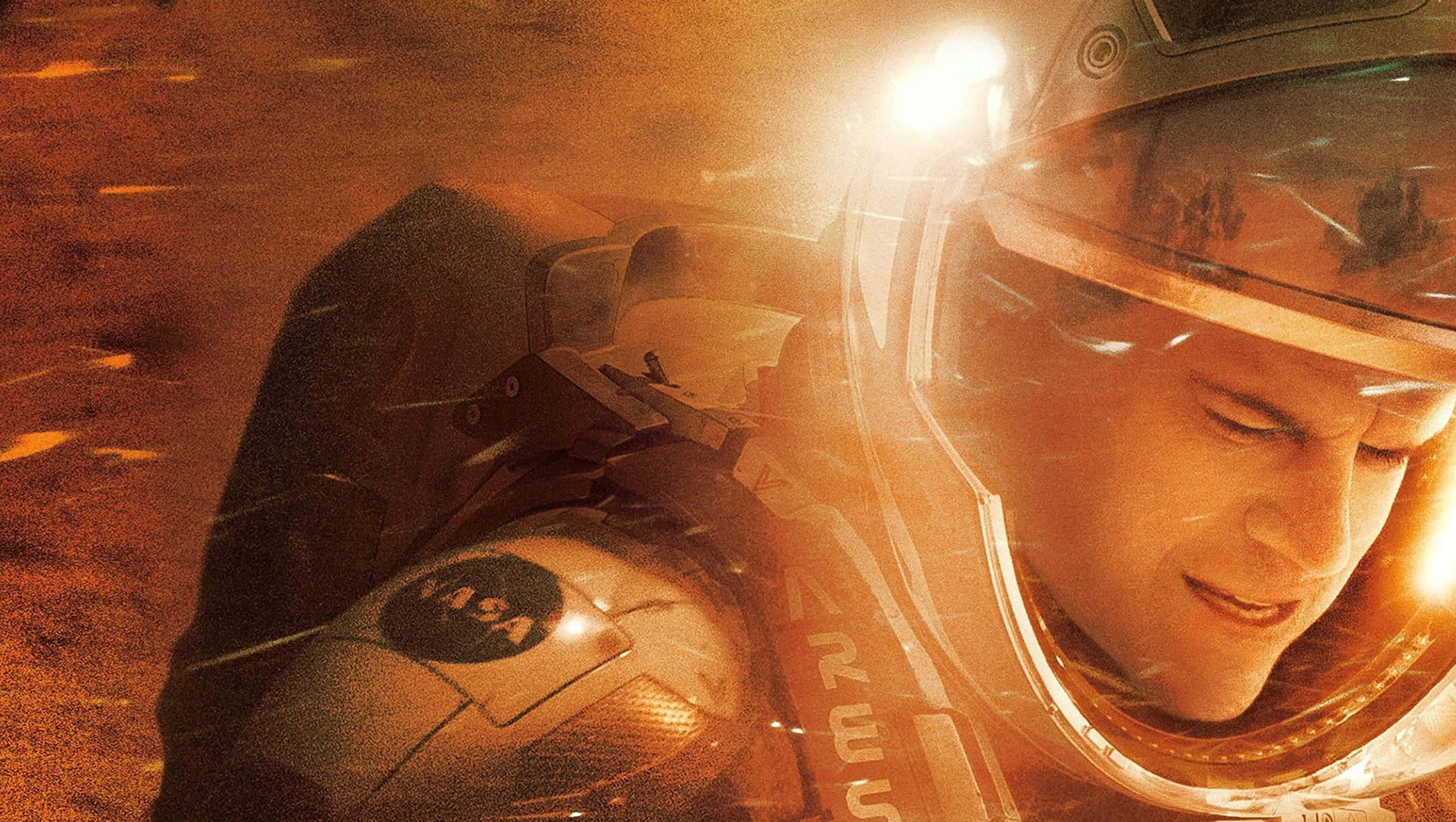 The Martian 桌布 壁紙 — 一位穿著NASA太空衣的太空人透過頭盔面罩微笑，背後在佈滿灰塵的外星行星上閃耀著明亮的光芒。
