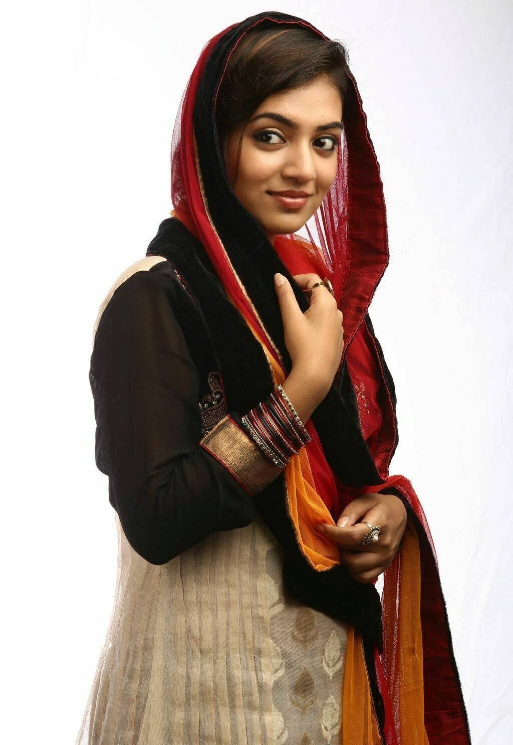 Indian 桌布 壁紙 — 一位穿著傳統服飾、披著紅黑相間杜帕塔的女性在純白背景前溫柔微笑。