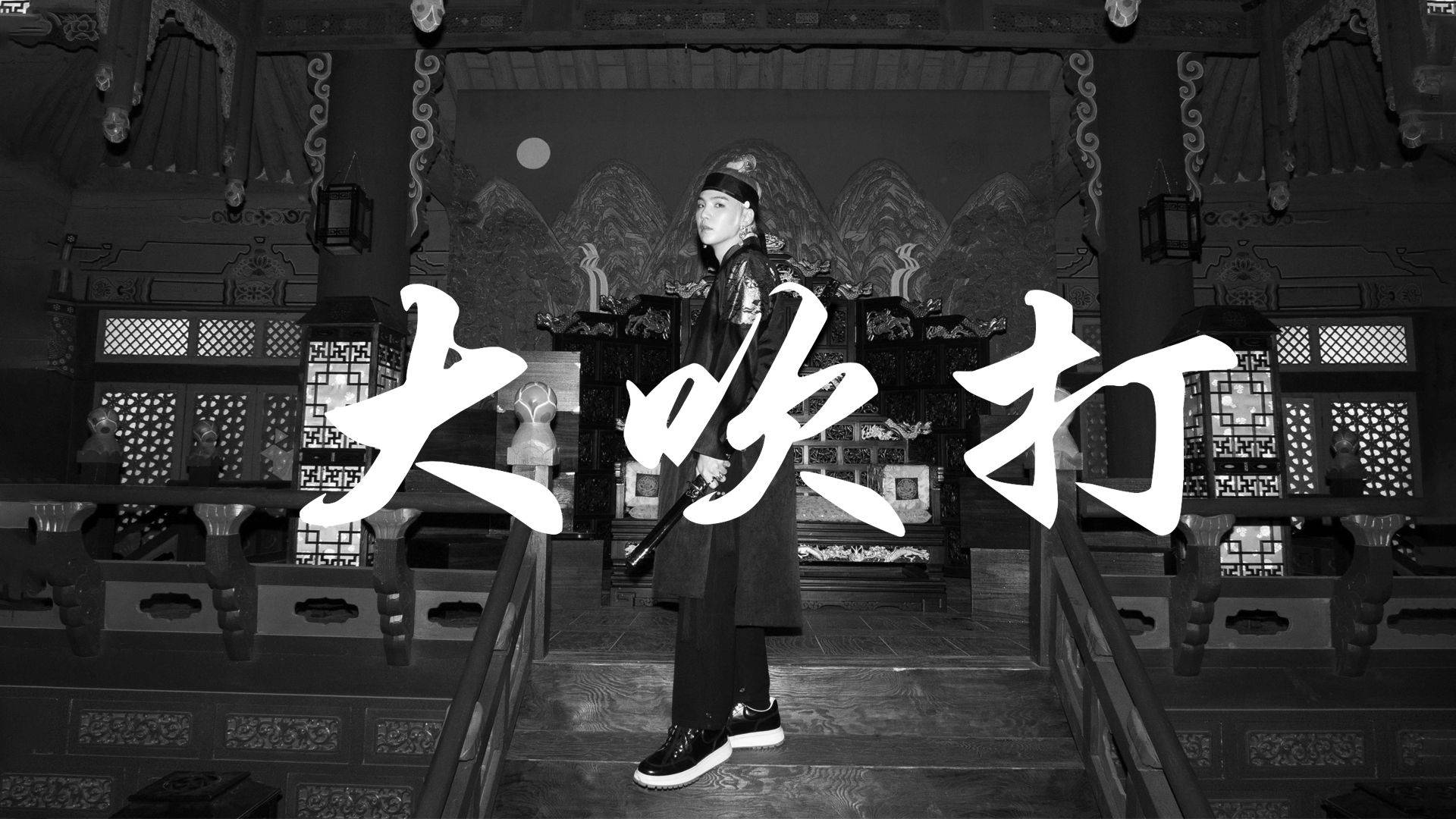 슈가 桌布 壁紙 — 一位穿著傳統服飾的人莊嚴地站在黑白相間、裝飾華麗的寺廟中，上面覆蓋著大型中文字。