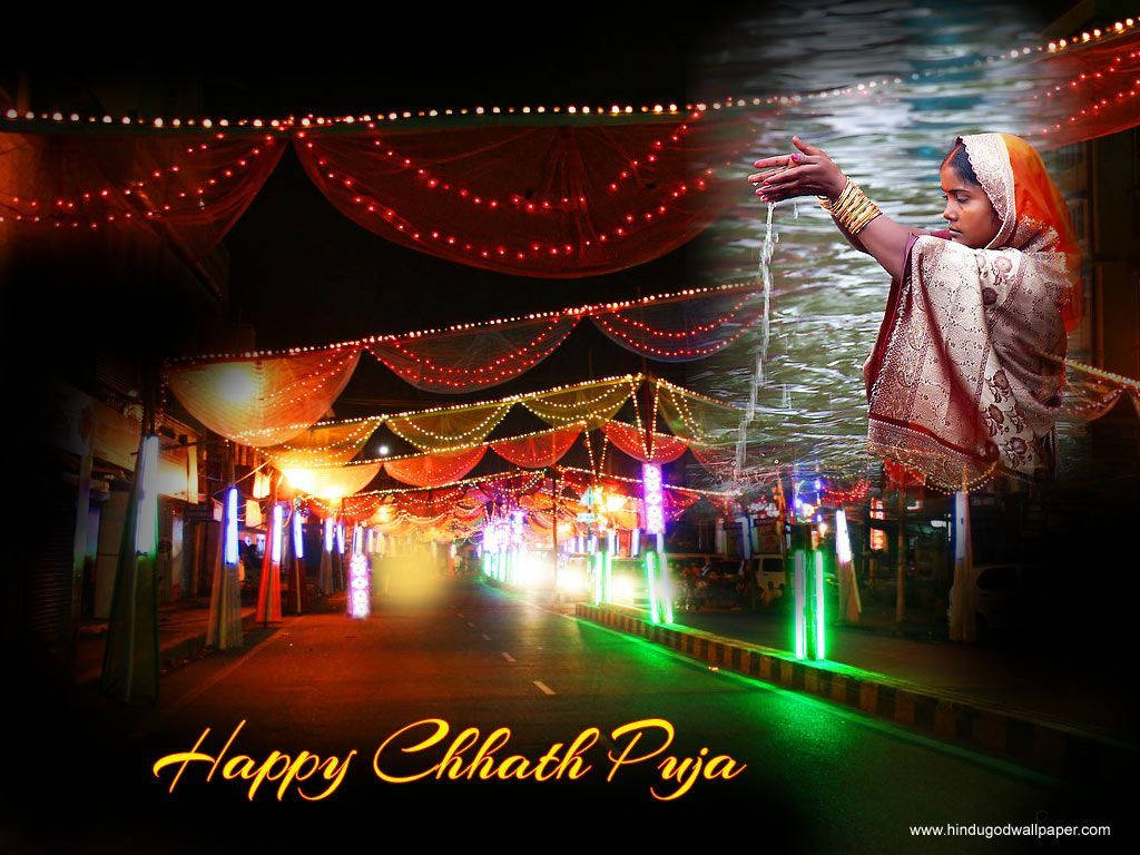 Chhath Puja 桌布 壁紙 — 一位穿著傳統服飾的女性在夜晚裝飾的街道上，在節日燈光下倒水，為Chhath Puja儀式。