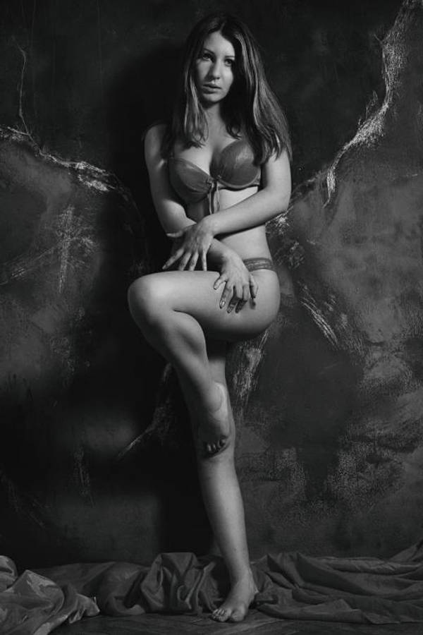 sexy bikini 桌布 壁紙 — 一位穿著內衣的女性在帶有紋理的深色背景前，以戲劇性的燈光優雅地擺姿勢。