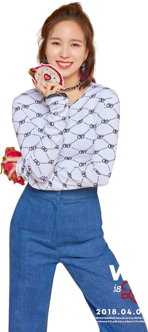 twice 桌布 壁紙 — 一位穿著圖案上衣和藍色牛仔褲的開朗年輕女性，手持粉紅色心形物品，笑容燦爛。