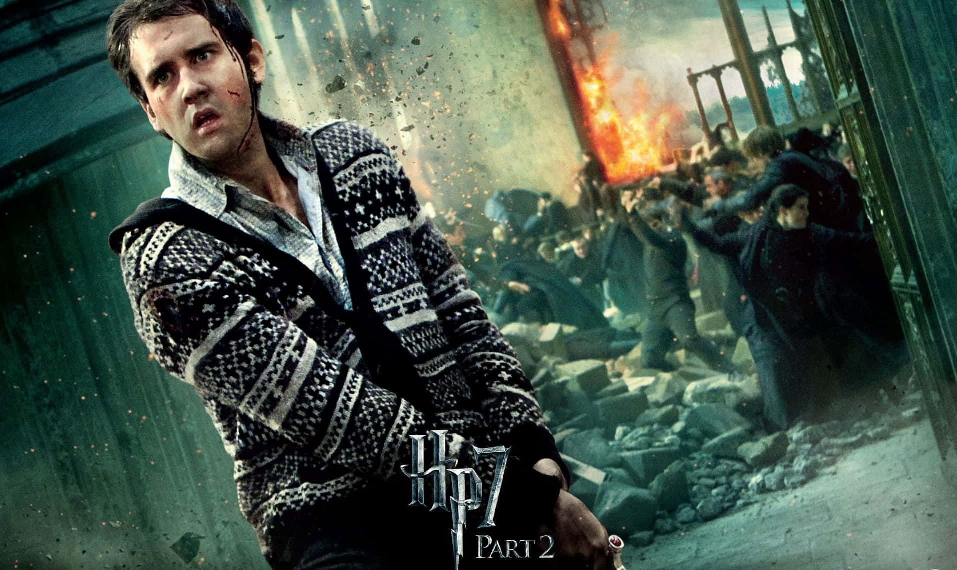 Neville Longbottom 桌布 壁紙 — 一位穿著圖案毛衣的年輕巫師在混亂的戰鬥場景中，挑釁地站在瓦礫和火焰之中。