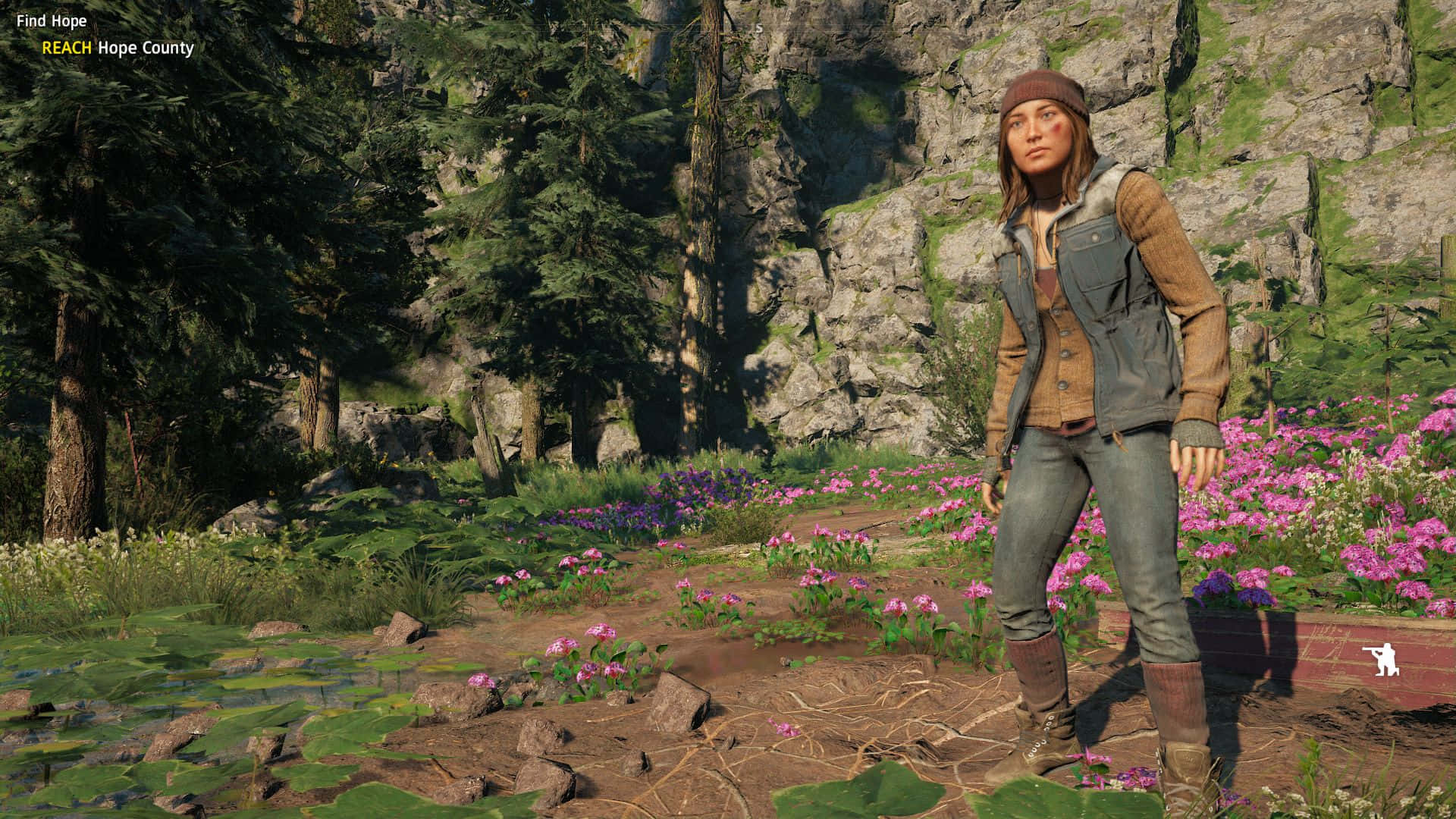 Far Cry New Dawn 桌布 壁紙 — 一位穿著堅固戶外裝備的女性，站在岩石懸崖邊，周圍是鮮豔的粉紅色野花和高聳的松樹。