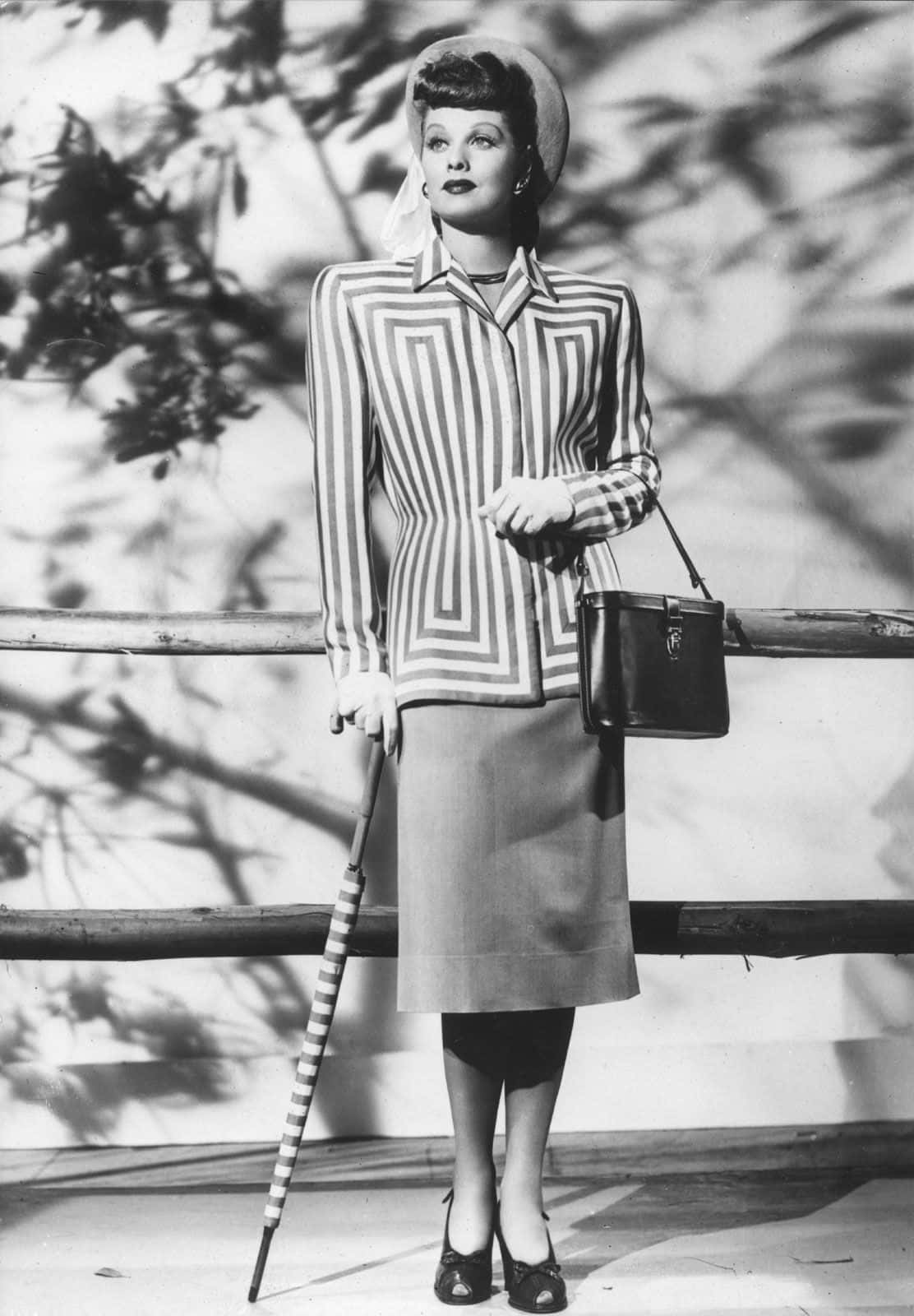 Black And White Fashion 桌布 壁紙 — 一位穿著幾何條紋西裝、手持相配雨傘和手袋的女士的復古黑白肖像。