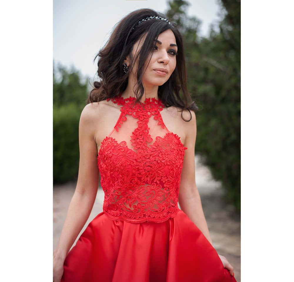 Red Lace Dress 桌布 壁紙 — 一位穿著搶眼紅色蕾絲掛頸連衣裙的女性站在戶外，身後是茂密的綠植。