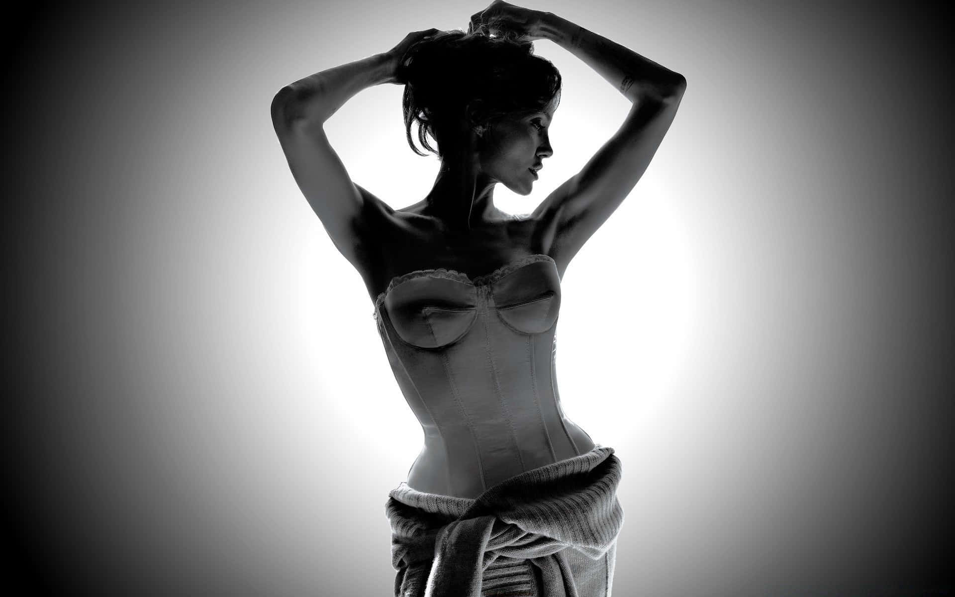 sexy woman 桌布 壁紙 — 一位穿著束胸衣的女性在明亮的背光下呈現剪影，雙手舉起放在頭髮上，營造出戲劇性的黑白肖像。