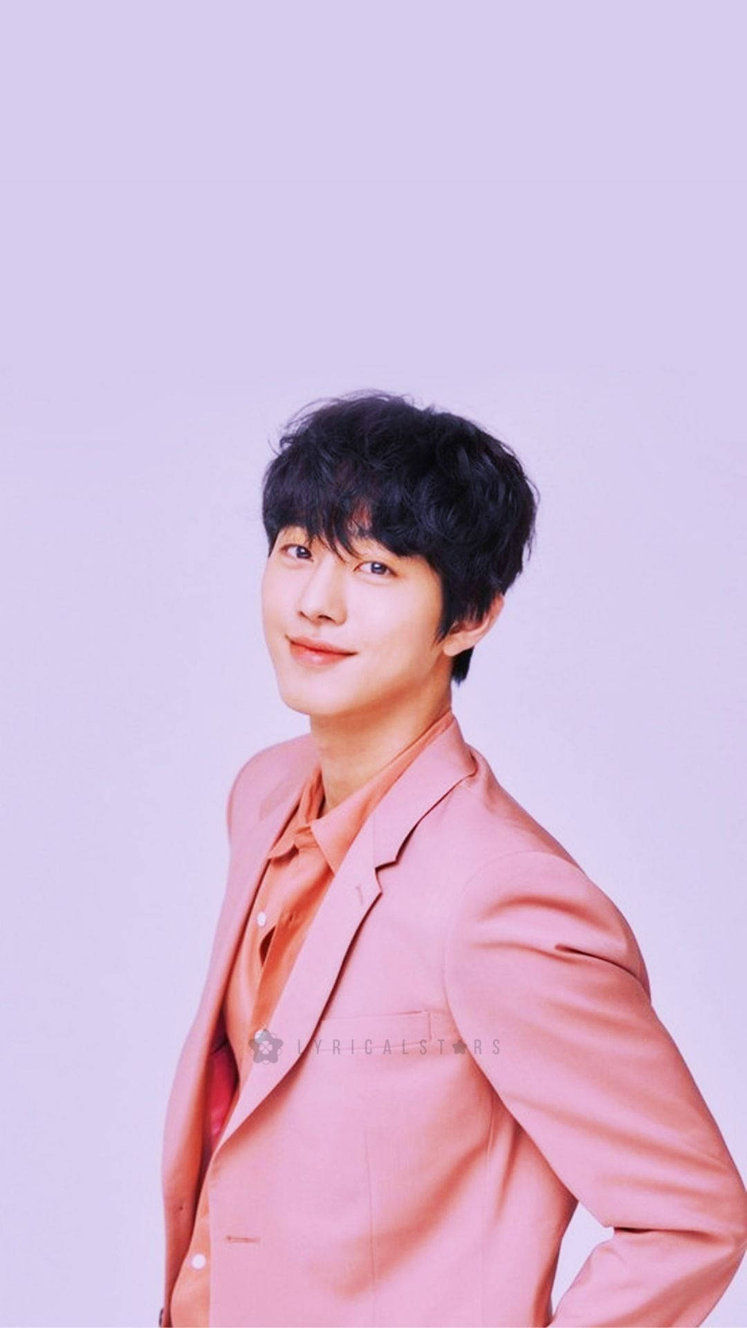 Ahn Hyo Seop 桌布 壁紙 — 一位穿著柔和粉紅色西裝外套的年輕男子，在淡紫色工作室背景前溫柔微笑。