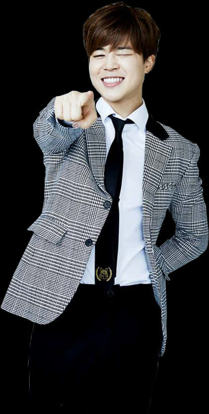 Formal Attire 桌布 壁紙 — 一位穿著格紋西裝外套的開朗年輕男子，在黑色背景前向觀眾眨眼並直接指向觀眾。