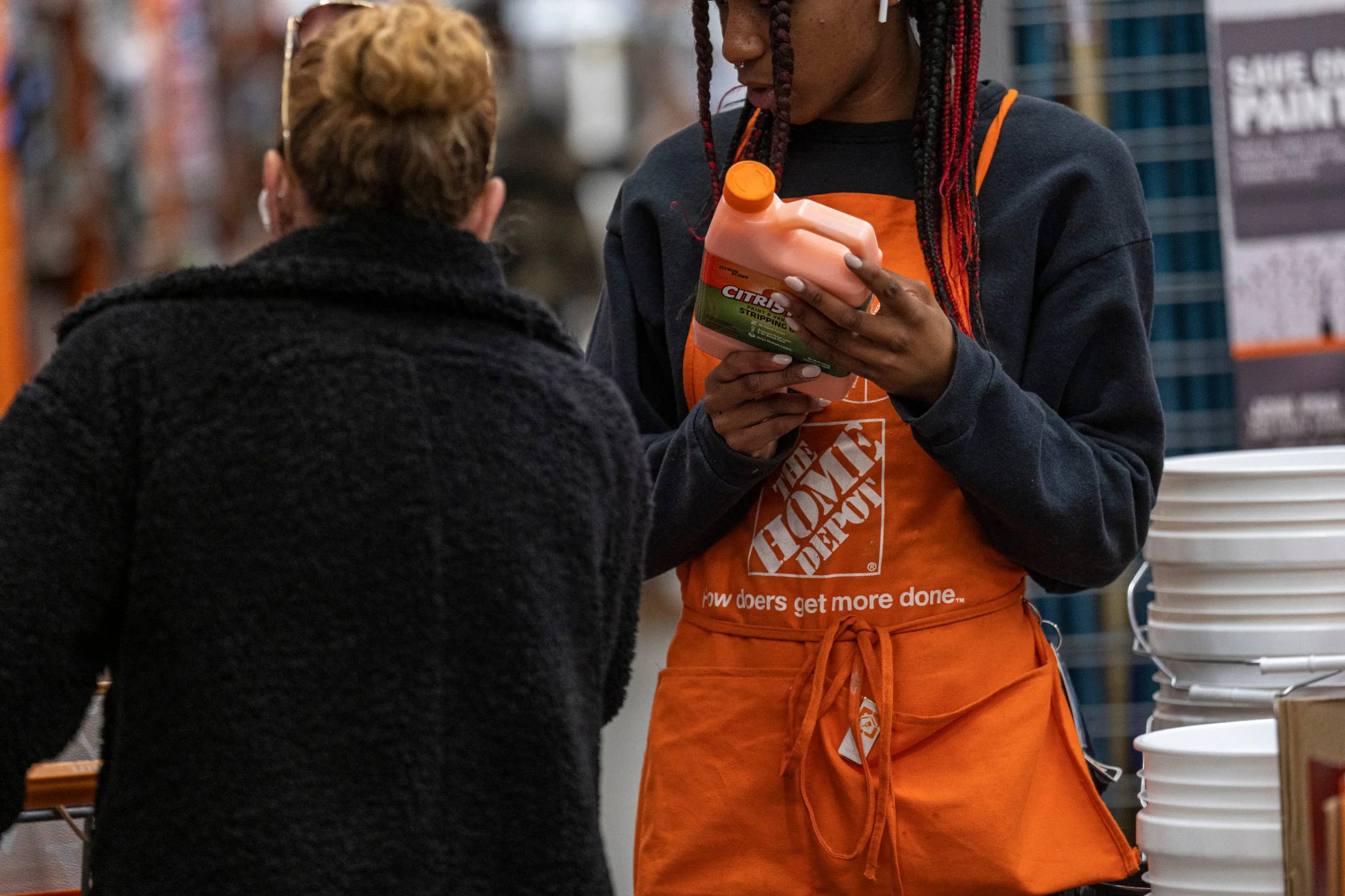 Home Depot 桌布 壁紙 — 一位穿著橙色圍裙的Home Depot員工在五金店幫助顧客選擇油漆。