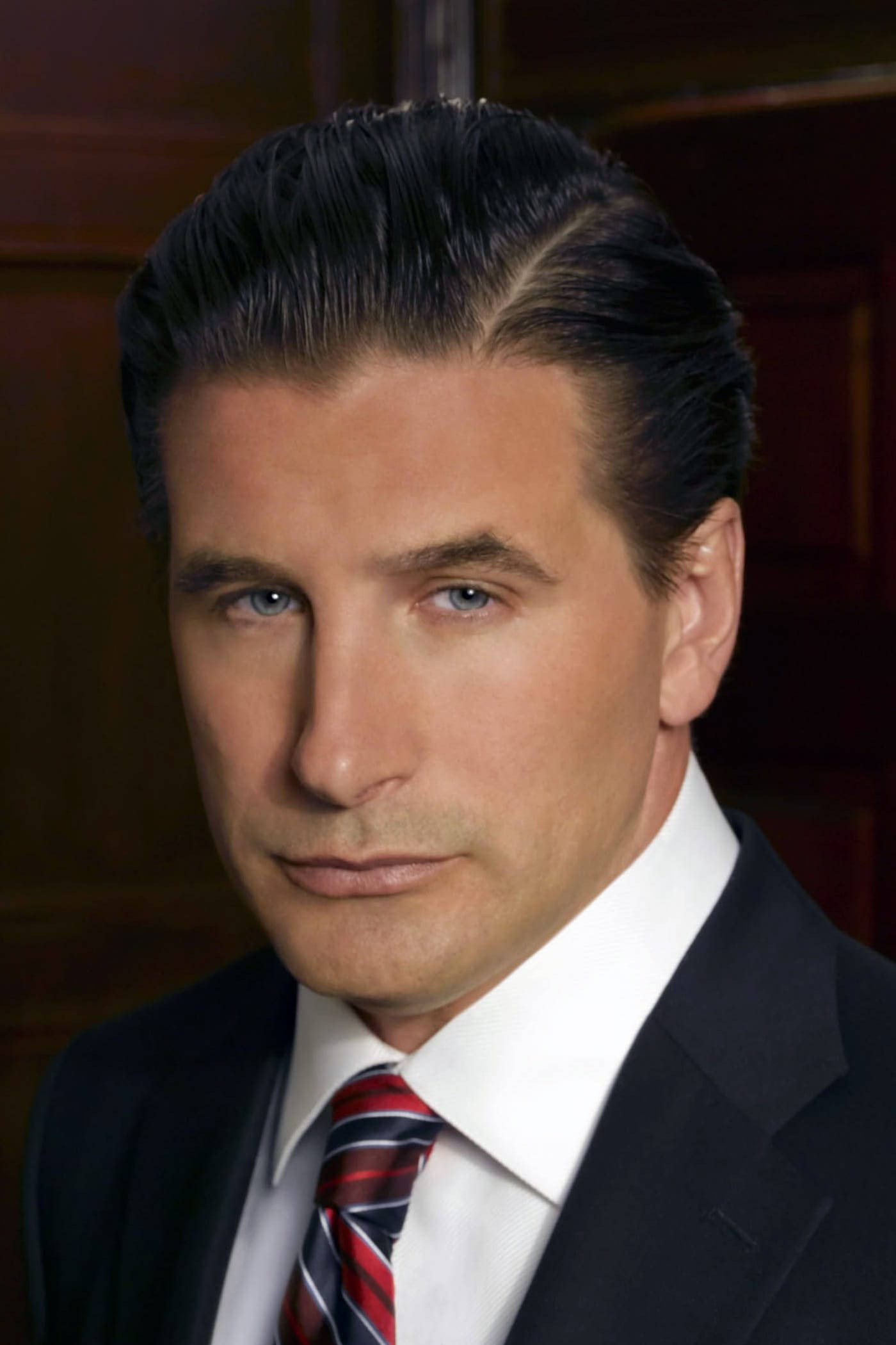 William Baldwin 桌布 壁紙 — 一位穿著深色西裝和紅色條紋領帶、衣著講究的男子，在華麗的木質背景下凝視著。