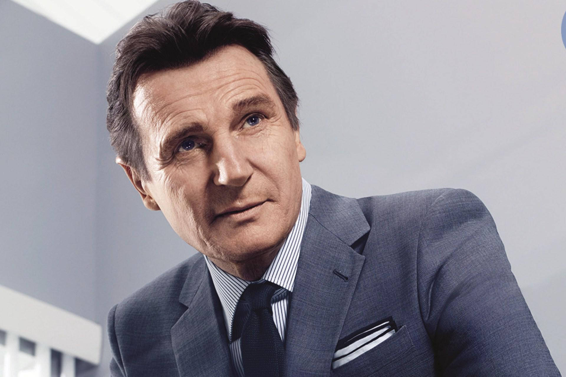 Celebrity 桌布 壁紙 — 一位穿著灰色西裝和條紋襯衫的時尚男士，在簡約的灰色背景下，帶著嚴肅的表情專注地凝視。