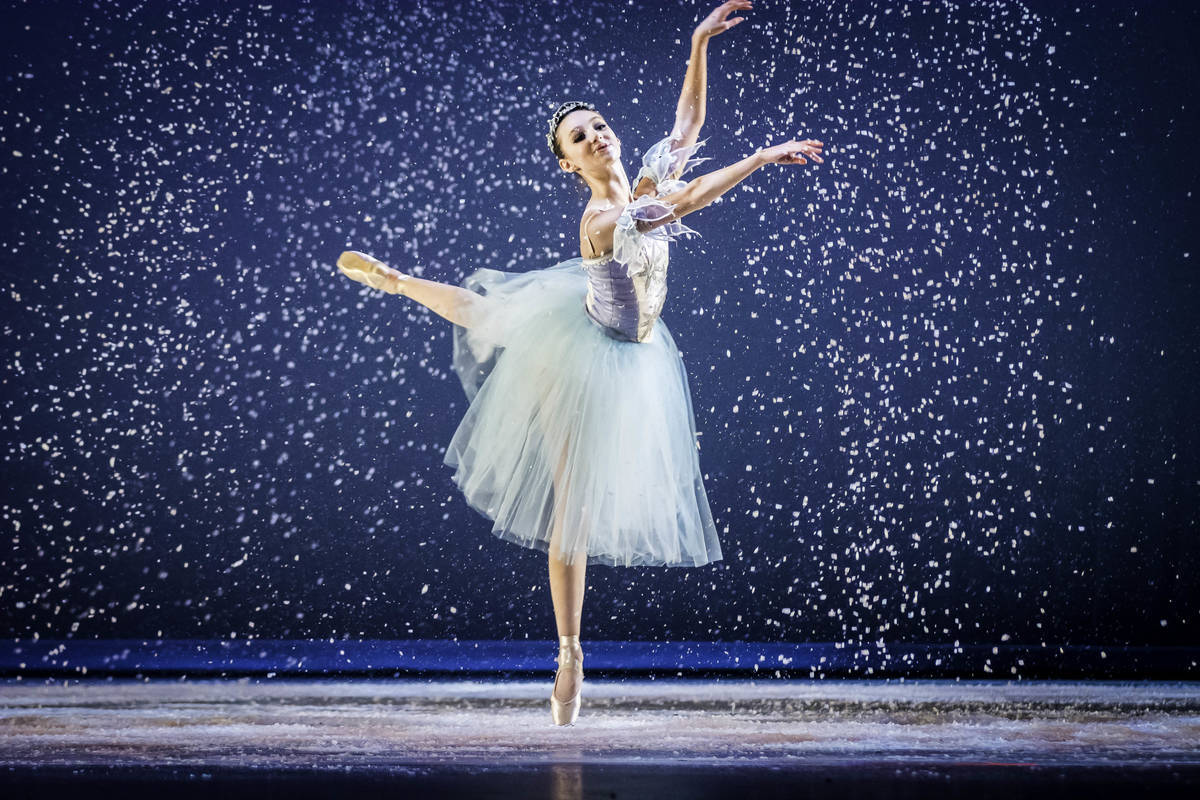 Ballet 桌布 壁紙 — 一位穿著白色芭蕾舞裙的芭蕾舞者在深藍色舞台背景下，優雅地踮起腳尖跳躍，雪花飄落。