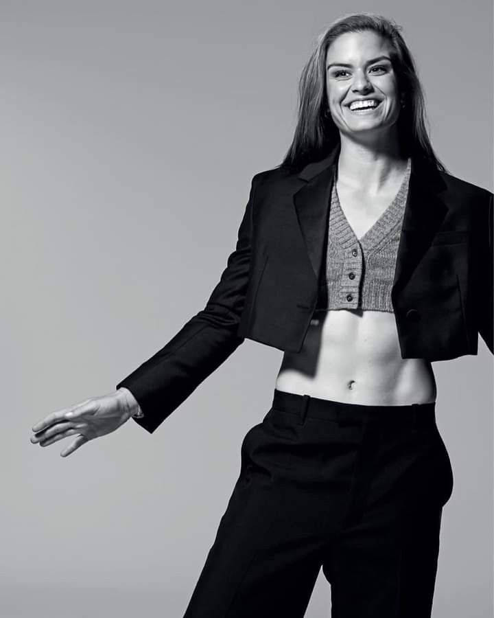 Beautiful Woman 桌布 壁紙 — 一位穿著短版西裝外套和長褲的女性，在純灰色攝影棚背景前燦爛微笑。