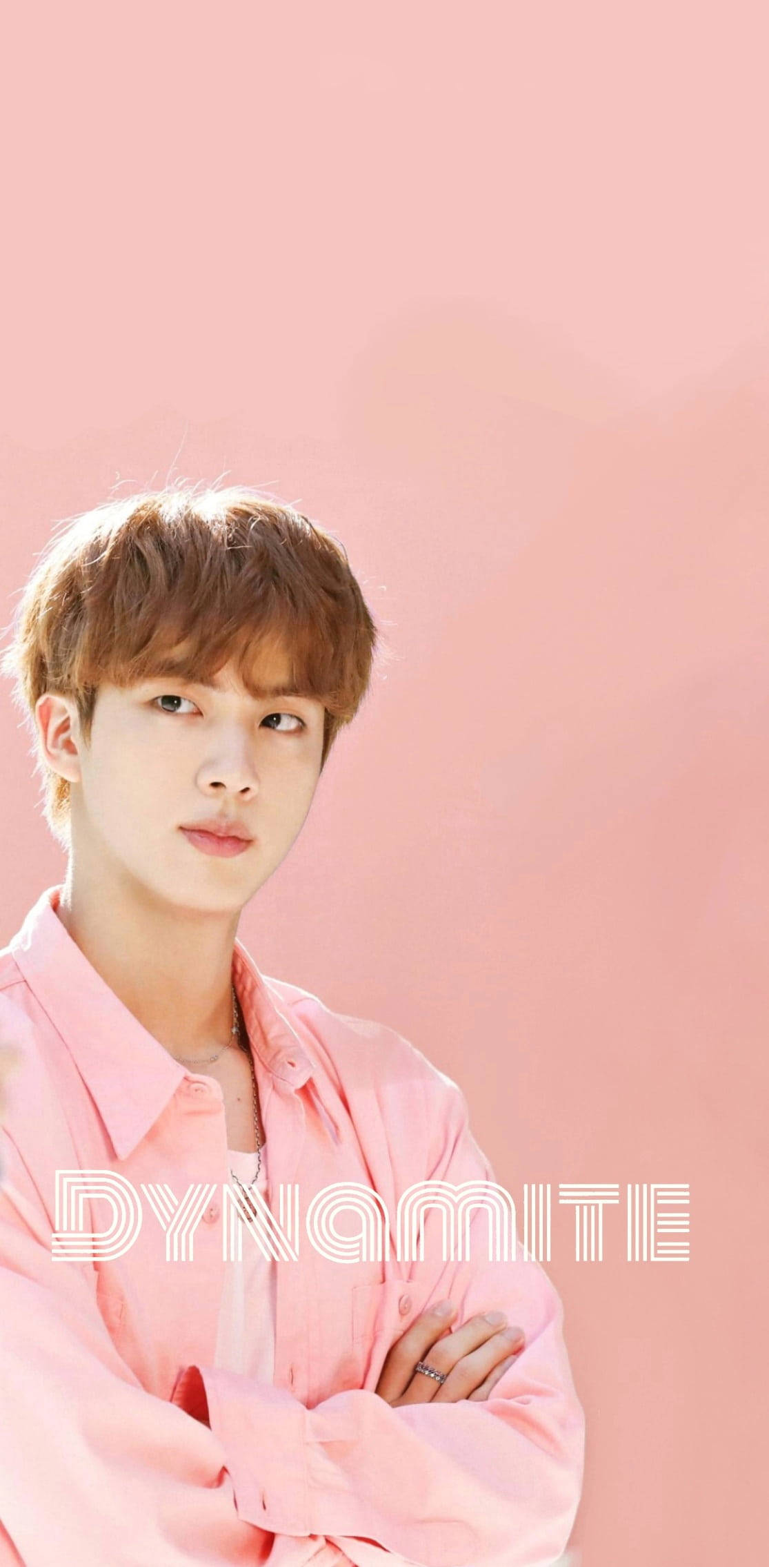 BTS Jin 桌布 壁紙 — 一位穿著粉紅色襯衫的年輕男子自信地站在純粉紅色背景前，上面覆蓋著「DYNAMITE」一詞。