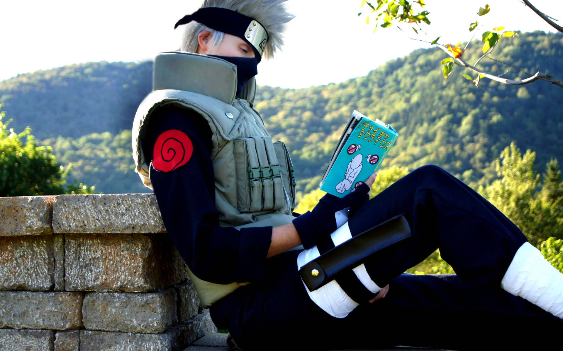 Reading 桌布 壁紙 — 一位穿著精細忍者服裝的角色扮演者，在森林山坡的石牆上放鬆閱讀漫畫。