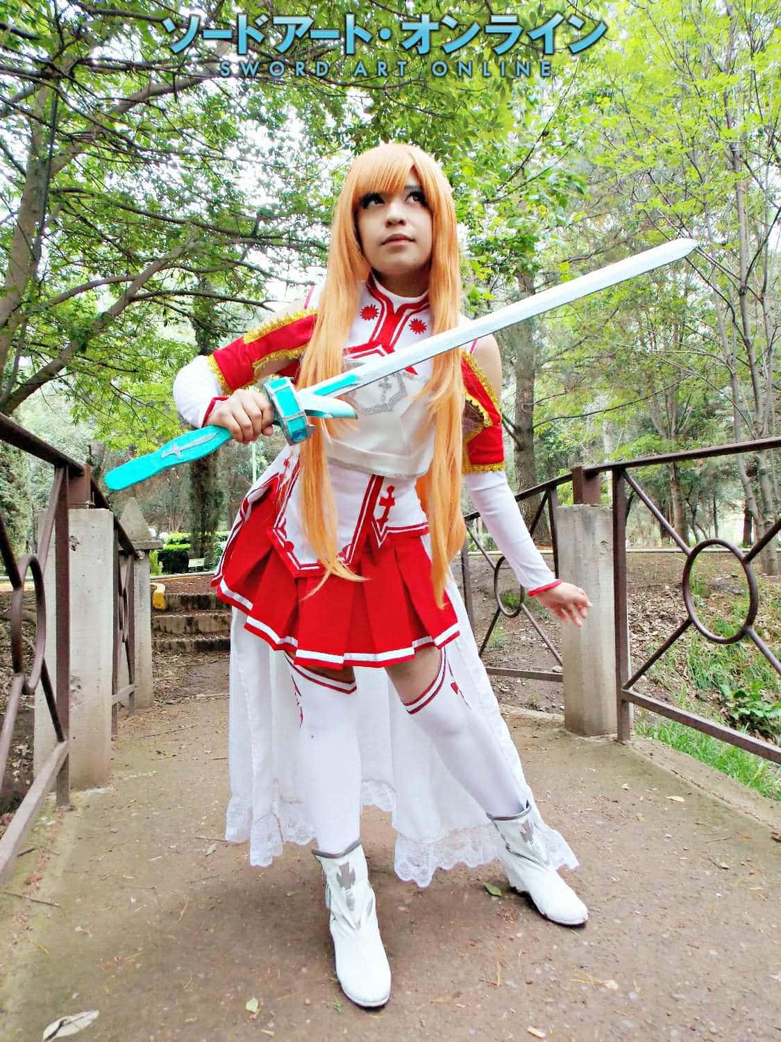 Sword Art Online Cosplay 桌布 壁紙 — 一位穿著紅白藍色刀劍神域服裝的角色扮演者，在公園橋上手持發光劍擺出姿勢。