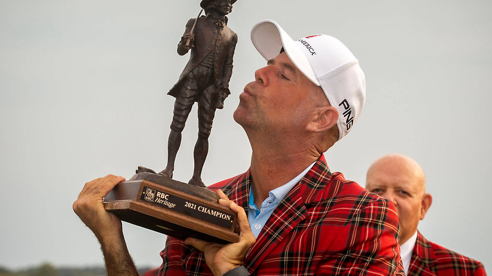 Trophy 桌布 壁紙 — 一位穿著紅色格子外套的高爾夫球手在陰天親吻他的2021年RBC傳承賽獎盃。