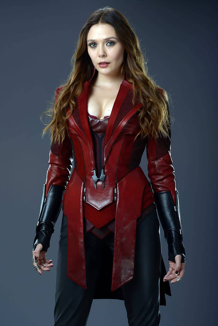 Wanda 桌布 壁紙 — 一位穿著紅黑皮革超級英雄服裝的女性自信地站在深灰色工作室背景前。