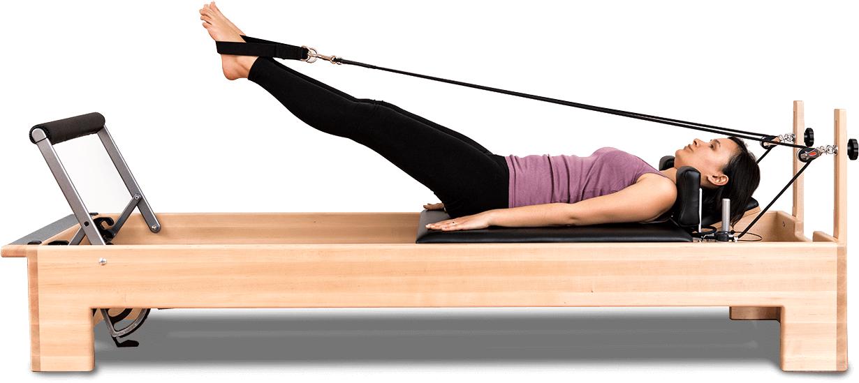 Pilates 桌布 壁紙 — 一位穿著紫色上衣的女性在黑色背景下的木製塑身機上進行皮拉提斯運動。