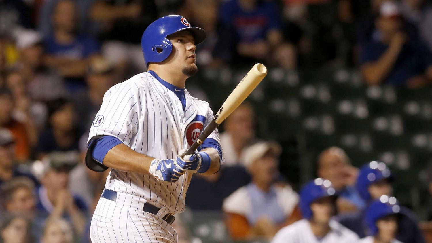 Chicago Cubs 桌布 壁紙 — 一位穿著細條紋球衣的芝加哥小熊隊棒球選手，在球場燈光下揮棒中，背景是模糊的球迷。
