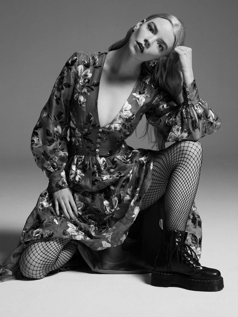 Anya 桌布 壁紙 — 一位穿著花卉連衣裙和漁網襪的女性在單色工作室中跪下，光線戲劇性。