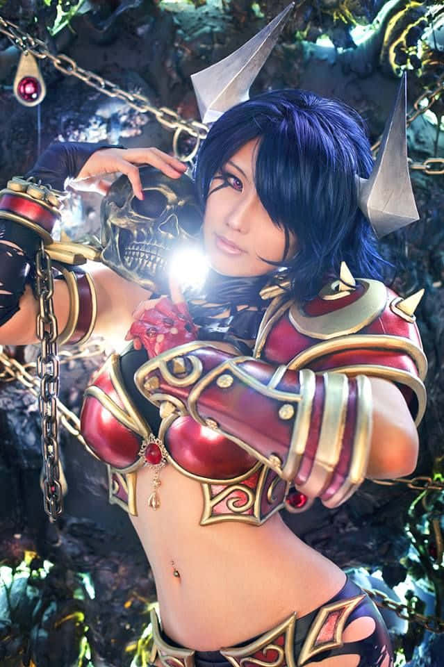 Queen Of Pain 桌布 壁紙 — 一位穿著華麗紅金盔甲、帶有骷髏和鏈條圖案的cosplayer在黑暗森林中擺姿勢。