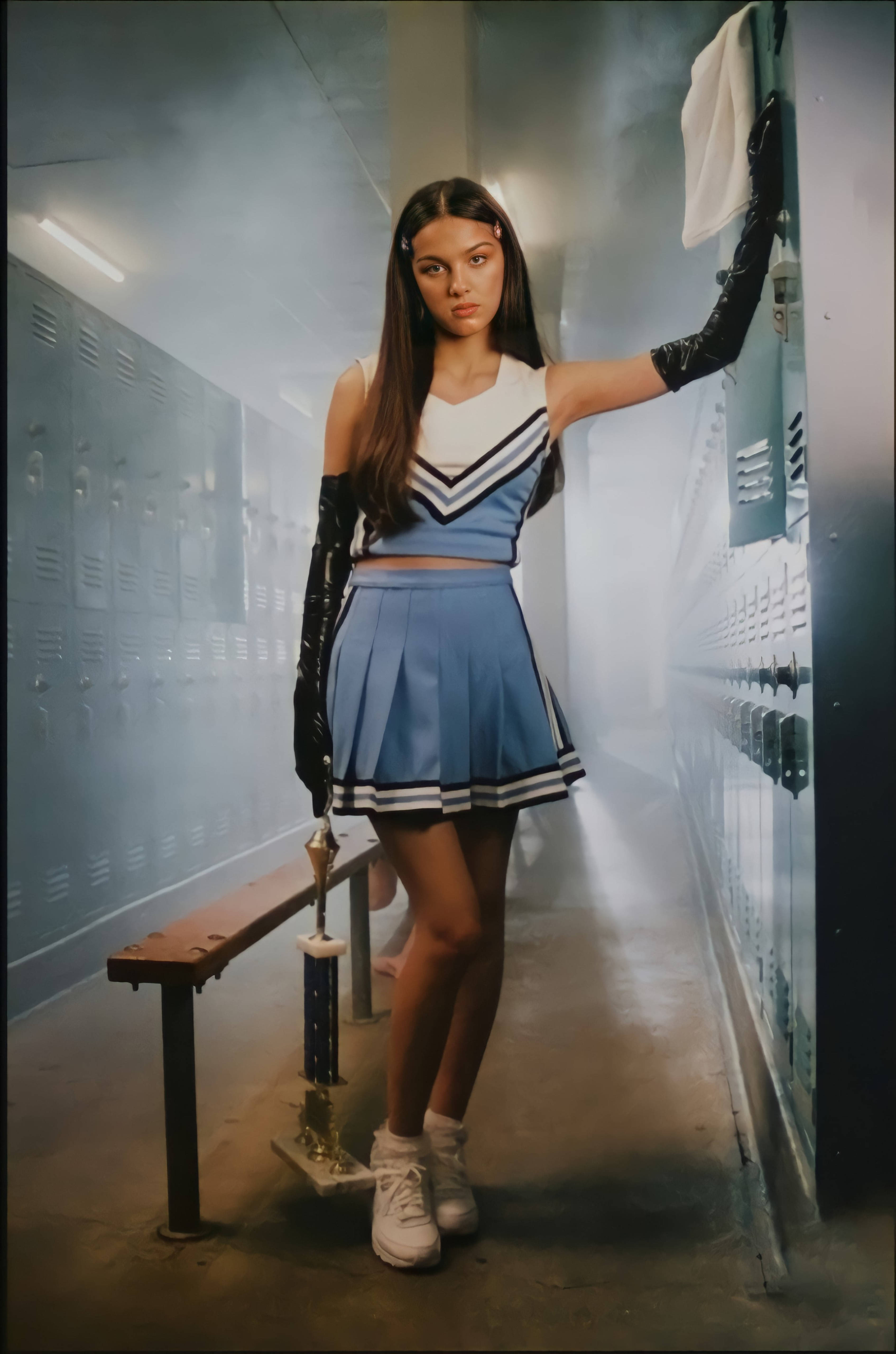 奧莉維亞·羅德里戈 桌布 壁紙 — 一位穿著藍白制服的啦啦隊員在煙霧瀰漫的學校走廊自信地站著，手裡拿著一個獎盃。