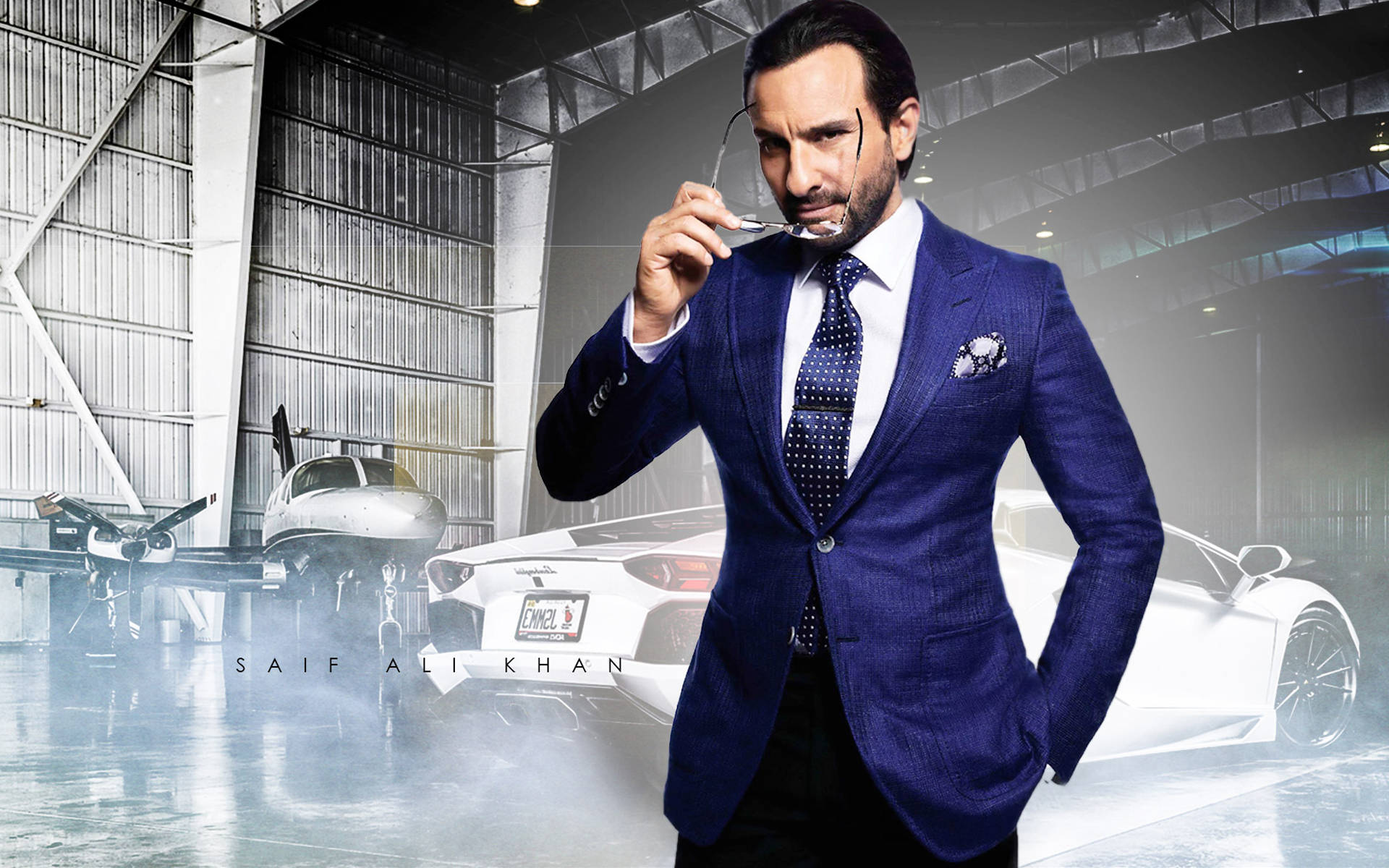 Saif Ali Khan 桌布 壁紙 — 一位穿著藍色西裝、衣著講究的男子，在霧氣瀰漫的機庫中，旁邊有一輛白色跑車和私人飛機，手持眼鏡。