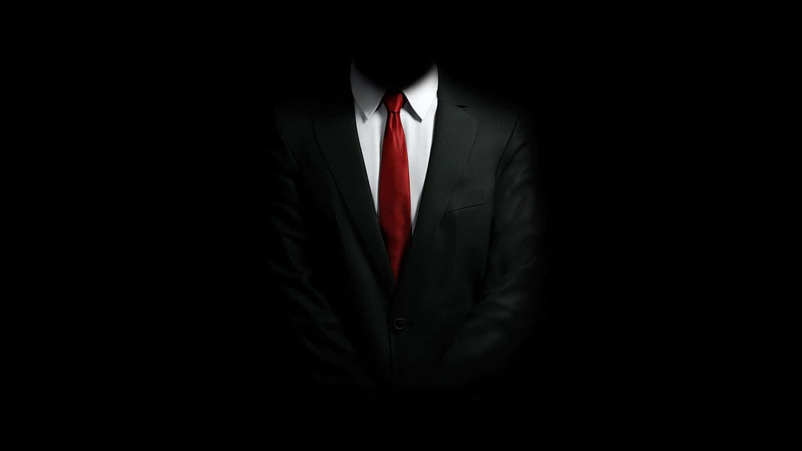 一位穿著西裝打領帶的男子站在黑暗中 壁紙