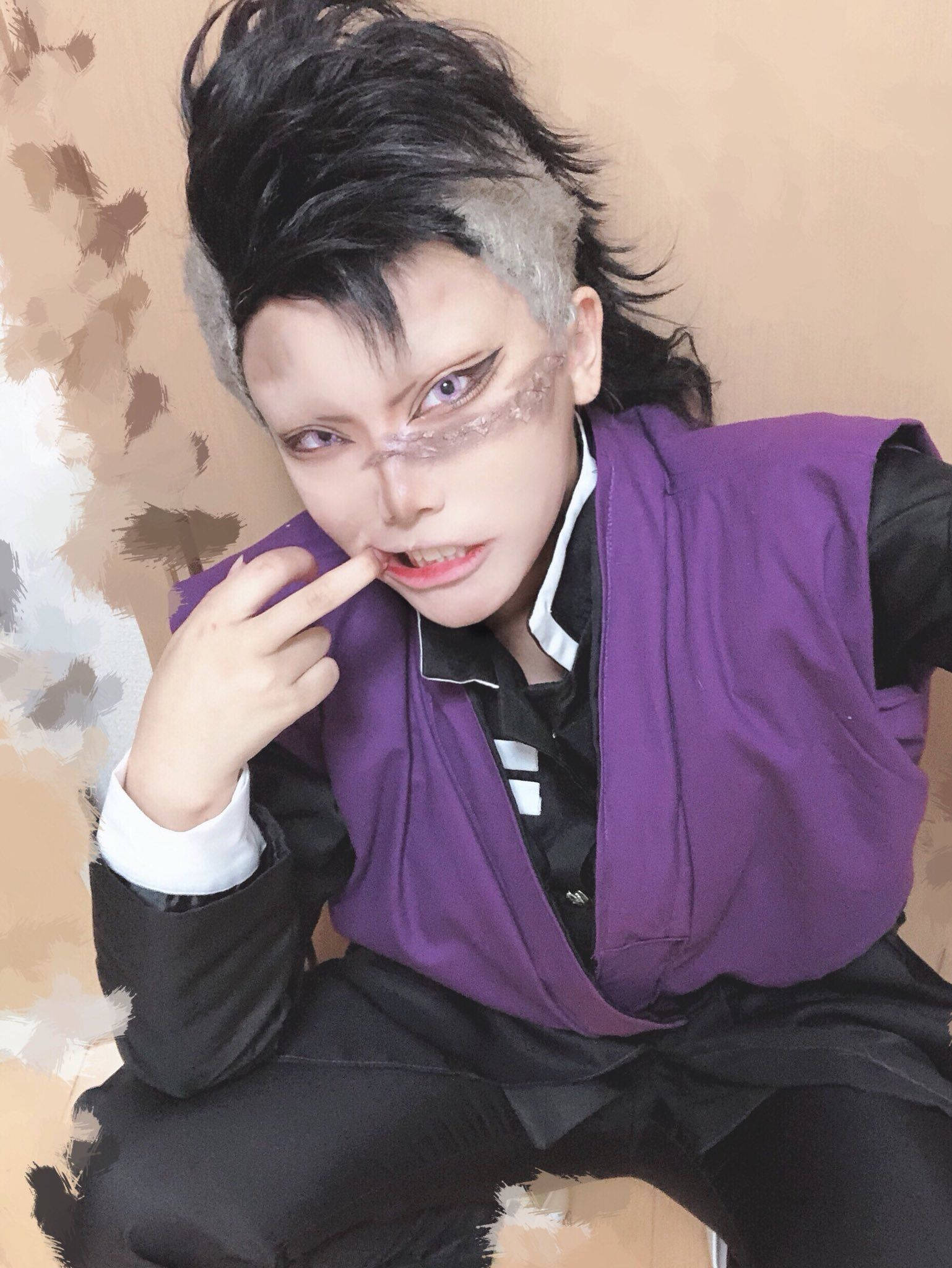 genya 桌布 壁紙 — 一位穿著角色扮演服裝的人，擁有尖刺的黑灰色頭髮、紫色背心和戲劇性的化妝，將手指放在嘴唇上擺姿勢。