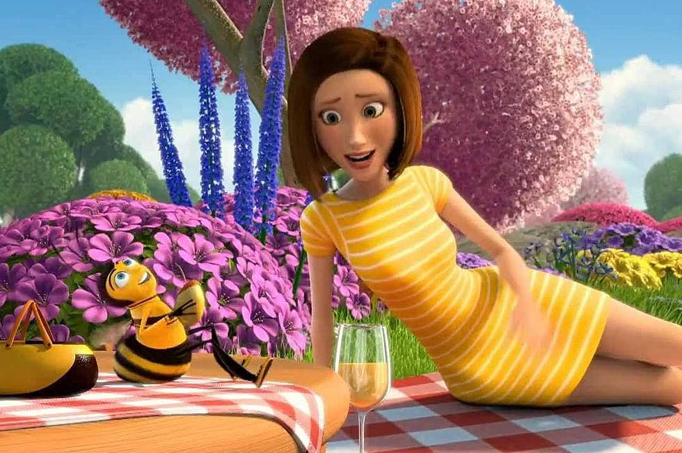 Animated 桌布 壁紙 — 一位穿著黃色條紋連衣裙的開朗動畫女性，躺在野餐毯上，旁邊有一隻蜜蜂，周圍是鮮豔的紫色和粉紅色花朵，在明亮的藍天下。
