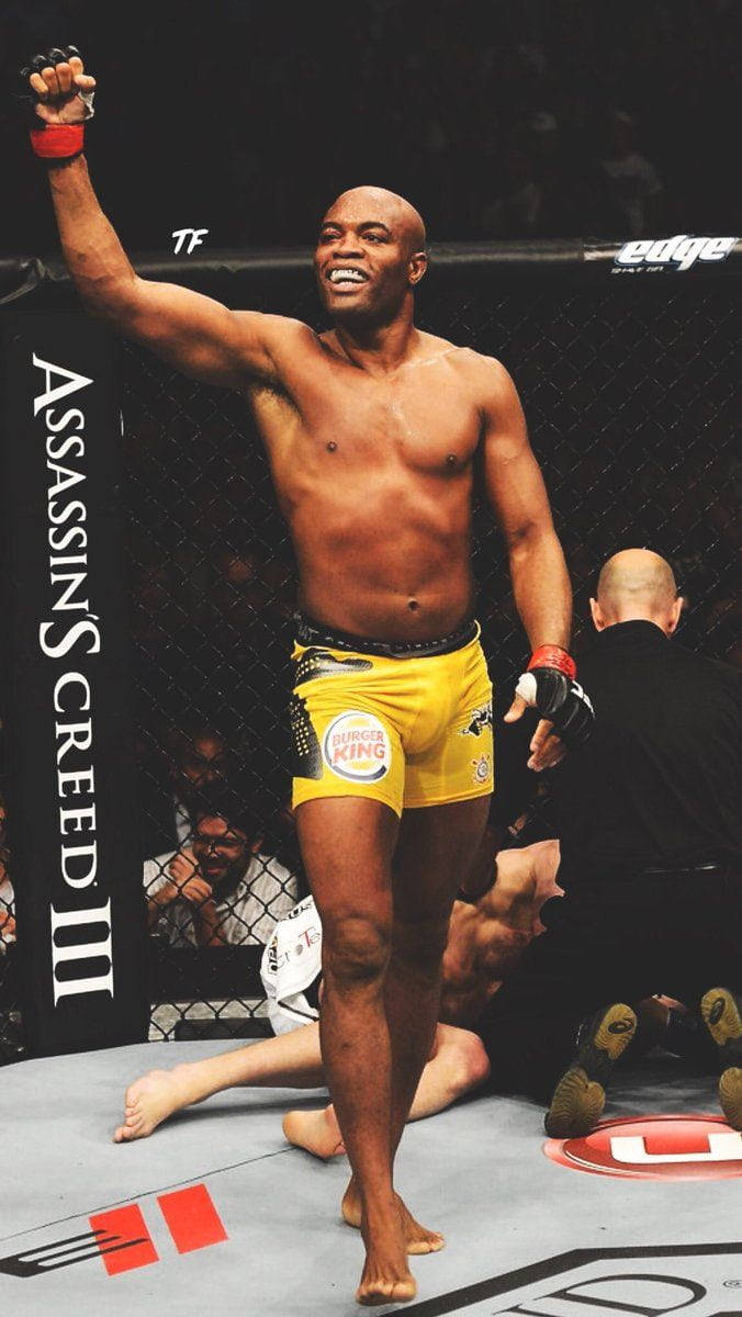 快樂 桌布 壁紙 — 一位穿著黃色短褲的勝利混合武術選手在UFC八角籠內高舉拳頭慶祝勝利，附近有倒下的對手。