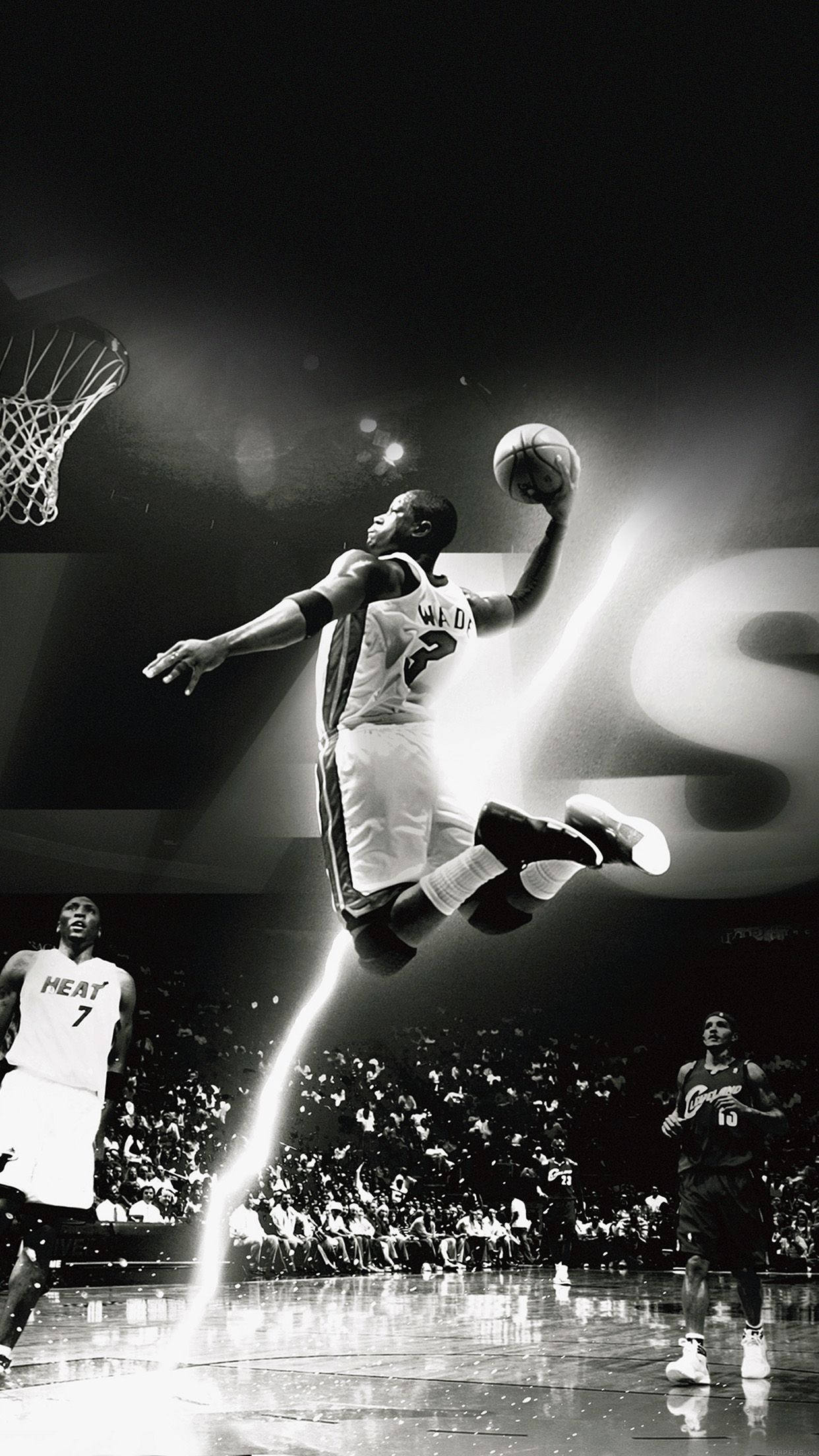 NBA 桌布 壁紙 — 一位籃球運動員在半空中飛翔，以黑白畫面呈現，戲劇性的聚光燈光束劃過場館，正在灌籃。