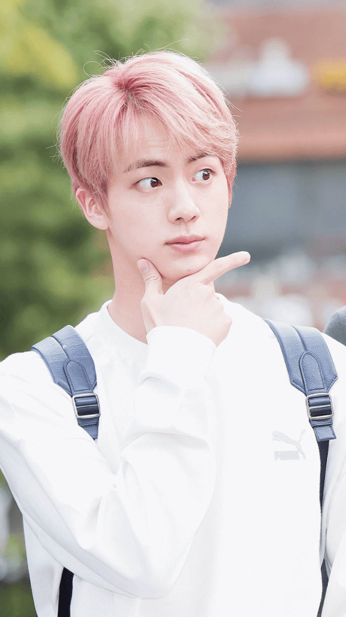 Jin 桌布 壁紙 — 一位粉紅色頭髮、身穿白色Puma運動衫的年輕男子，托著下巴若有所思地凝視著。