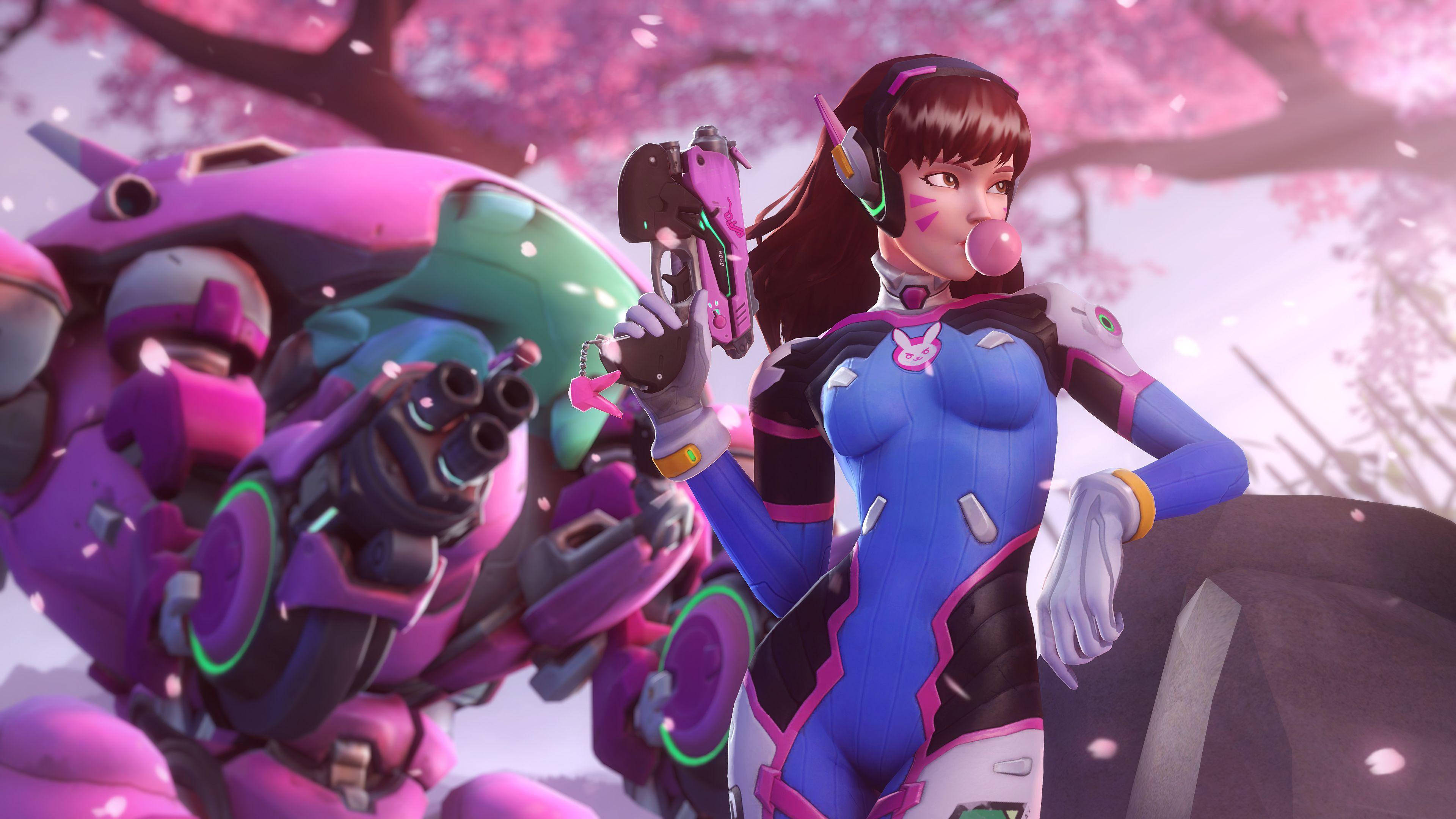 D.Va 桌布 壁紙 — 一位粉紅色頭髮的《鬥陣特攻》英雄穿著藍色和粉紅色盔甲，在櫻花樹下的大型機甲旁邊吹泡泡糖。