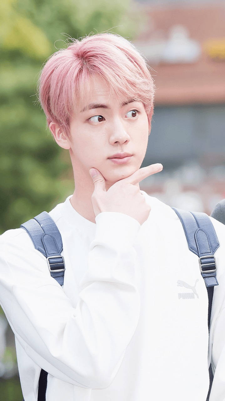 Cute Bts 桌布 壁紙 — 一位粉紅色頭髮的年輕男子穿著白色Puma運動衫，托腮沉思。