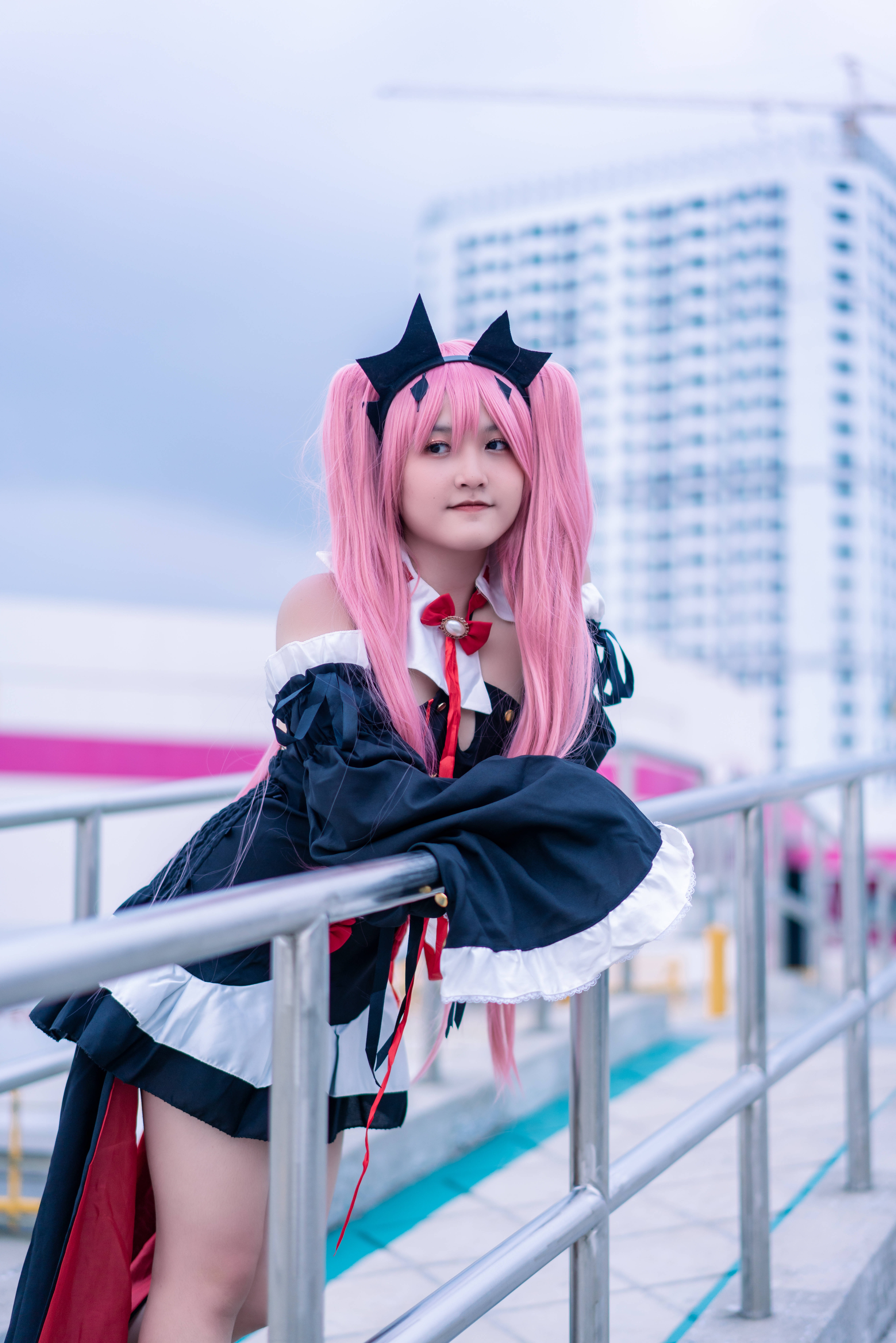 cosplay 桌布 壁紙 — 一位粉紅頭髮、戴黑色貓耳的角色扮演者，穿著女僕裝，以現代城市為背景擺姿勢。