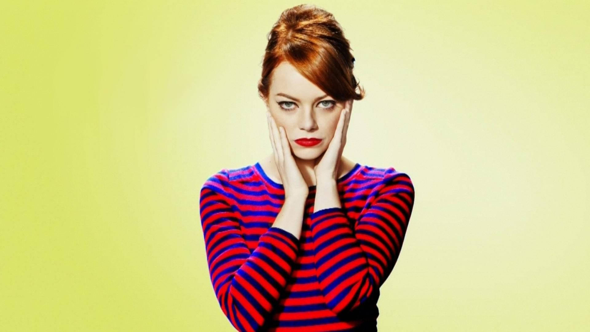 Emma 桌布 壁紙 — 一位紅髮、紅唇大膽的女性，穿著紅藍條紋毛衣，背景是淡黃色。